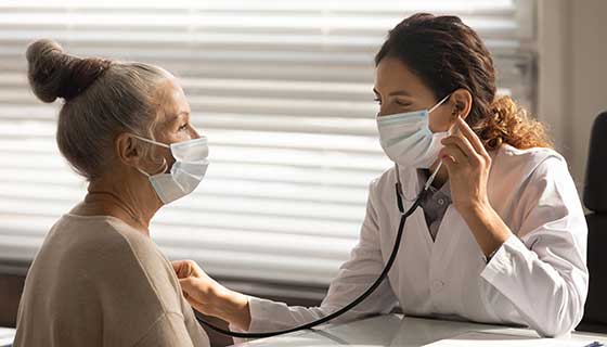 Doctor uses stethoscope to listen to her patient's heart